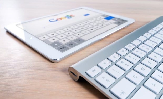 A tablet and keyboard on top of a table.